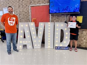 Tomas with dad at AVID sign